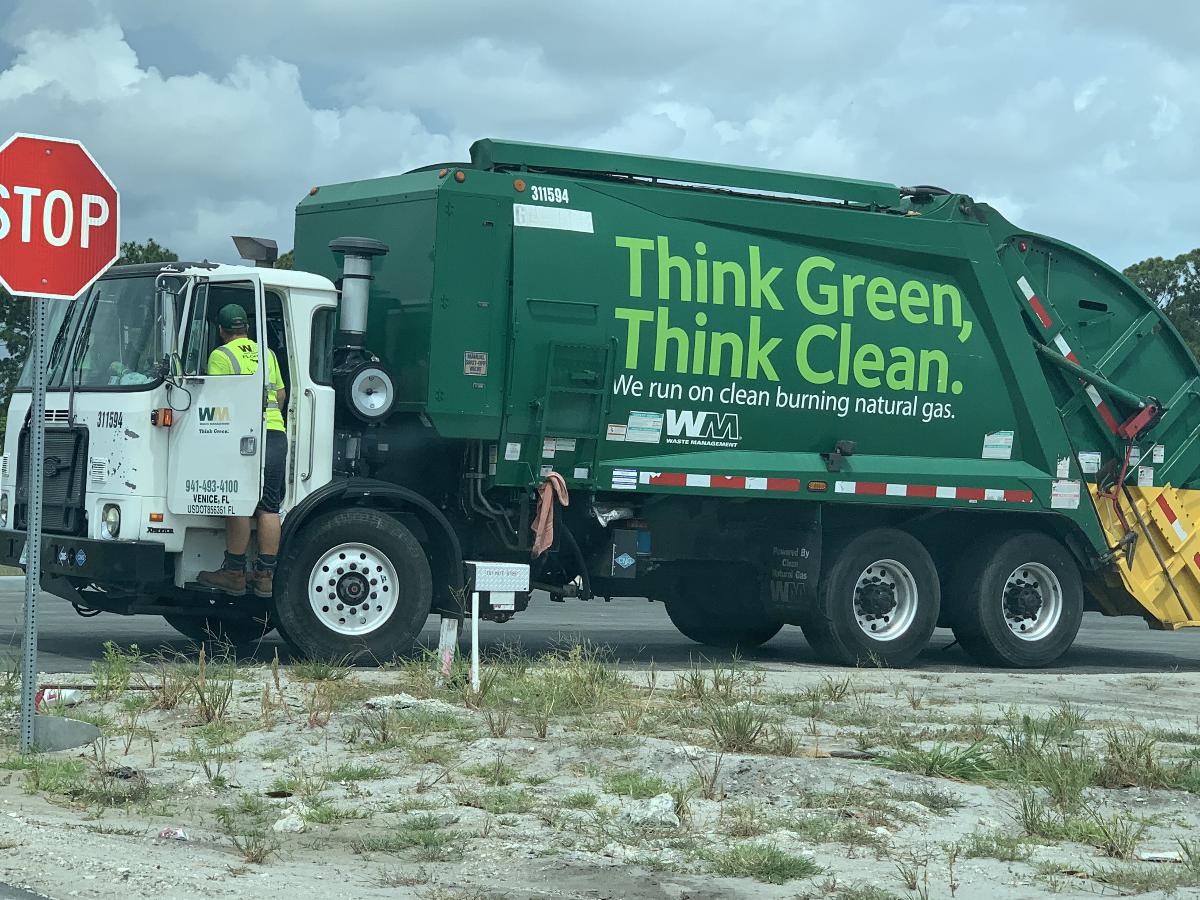 A garbage truck is parked on the side of the road.