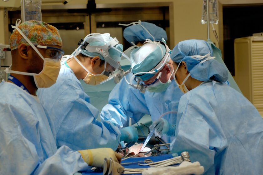 A group of surgeons performing surgery in an operating room.